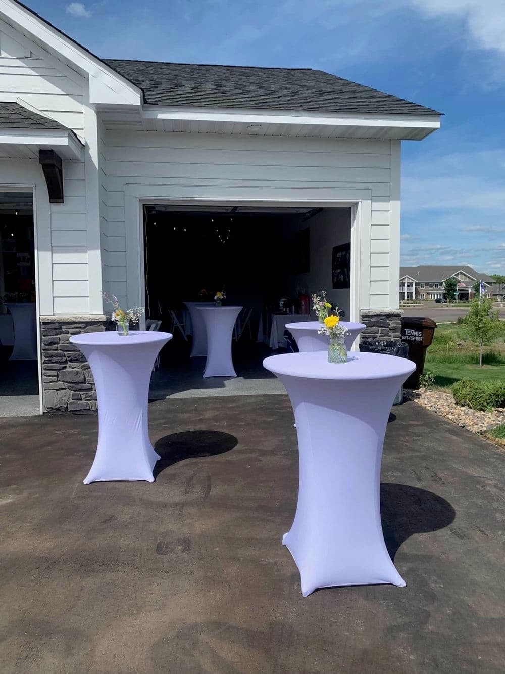 Elegant setup with lavender tablecloths and floral centerpieces for an outdoor event.